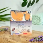 Savon pour peaux grasses de face, marbré orange et blanc, posé sur support bois. surgras à 8%